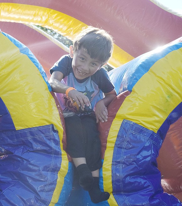 Smiling as he squeezes through the inflatable bounce course, Park Avenue School student Billy Larreategui, 7, gets ready to go through it again.