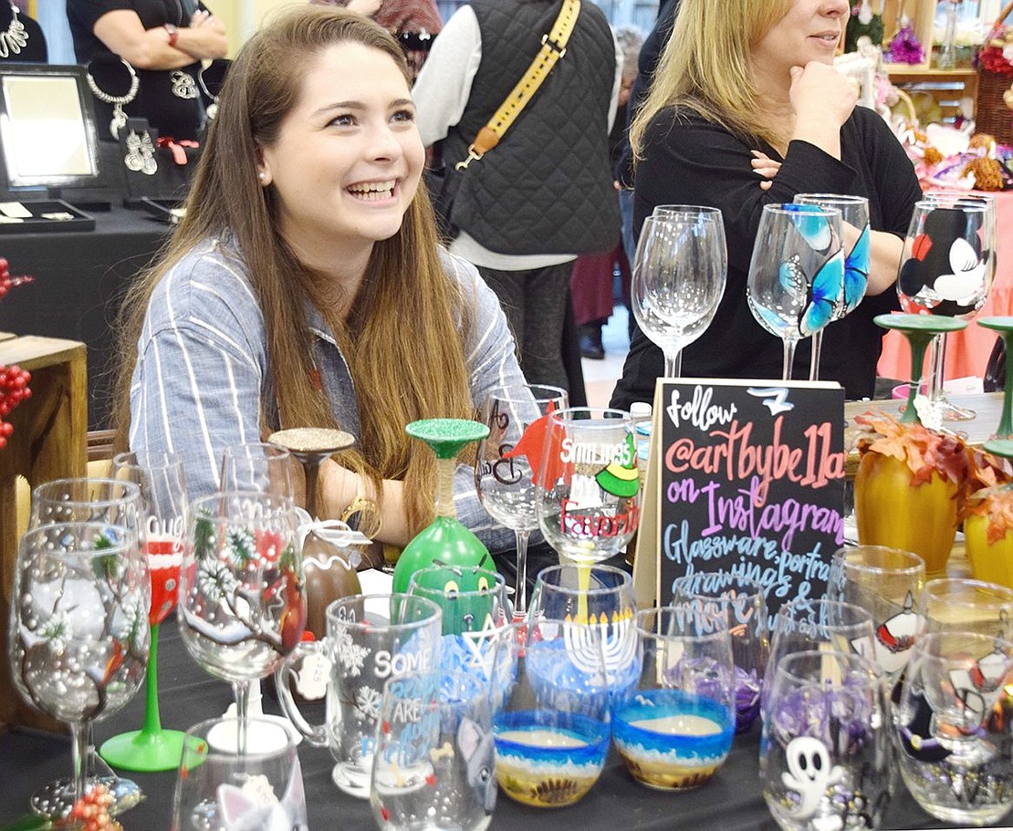 Surrounded by her hand-painted wine glasses portraying animals, characters and seasons, Isabella Roca laughs as she talks to art show attendees about her work. The Port Chester High School Class of ‘15 graduate was one of 15 local artists who showcased their work at the annual ART10573 exhibit at the Posillipo Community Center on Sunday, Oct. 20.