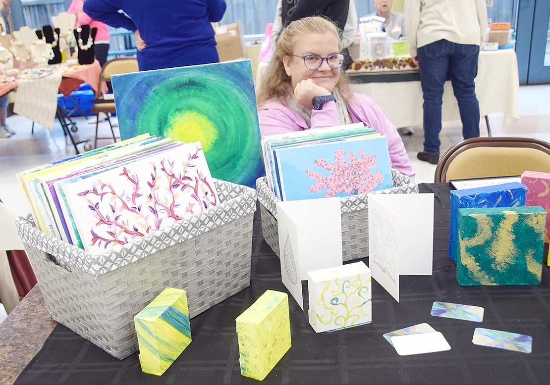 Manning her table of colorful paintings of varying sizes, Summit Avenue resident Lesley Zlabinger smiles for the camera.