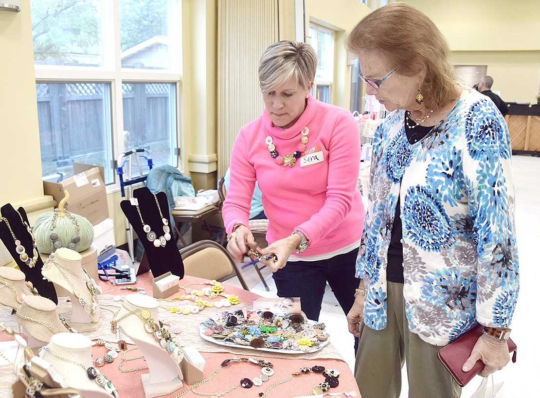 First-time featured artist Sara Swisher-Anderson shows Sue Covino, an ART10573 event co-chair of Leicester Street, the pendants she can make custom jewelry out of. The King Street resident repurposes vintage pieces to create unique necklaces.