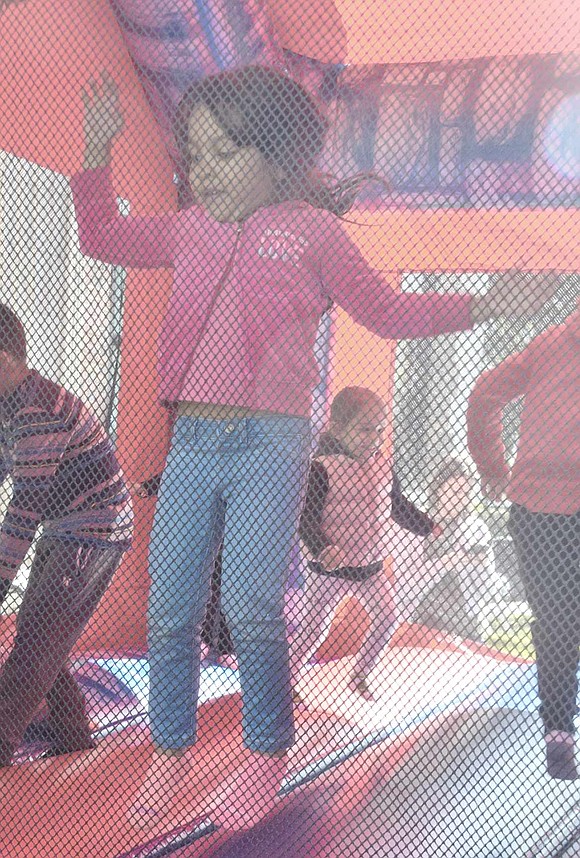 West Street resident Emma Rose Nunez  , 4, flies high as she jumps with other children in the bouncy house at the Park Avenue School fall carnival.