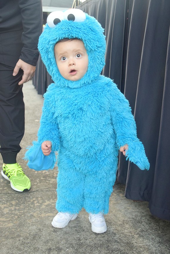 Dressed as the Cookie Monster, Barrett Lane 1-year-old Antonio Bellamusto wanders around the park looking for sweet treats.
