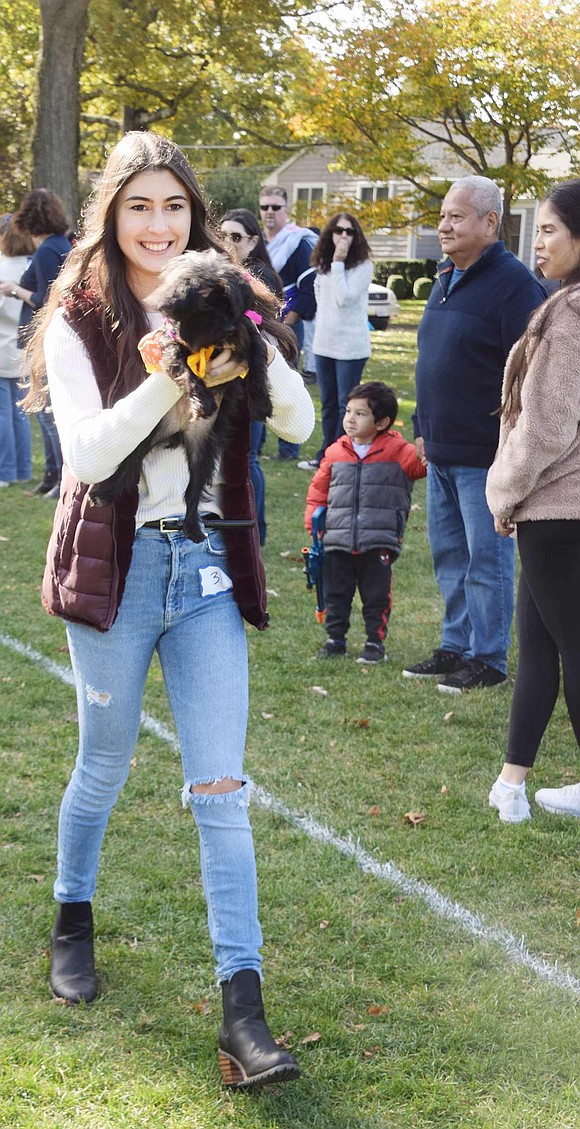 Wearing one of the more unique costumes, Sprinkles, dressed as a candy corn princess, is held by Harrison resident Kaley Arozamena as she walks her around the park to be judged.