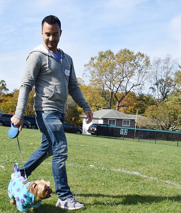 White Plains resident Kabir Valencia guides his dog Spike, dressed up as Sully from “Monsters, Inc.” for Halloween, around the course. At the end of the competition, Spike was crowned the first-place winner of this year’s Howl-O-Ween in the Park costume contest.