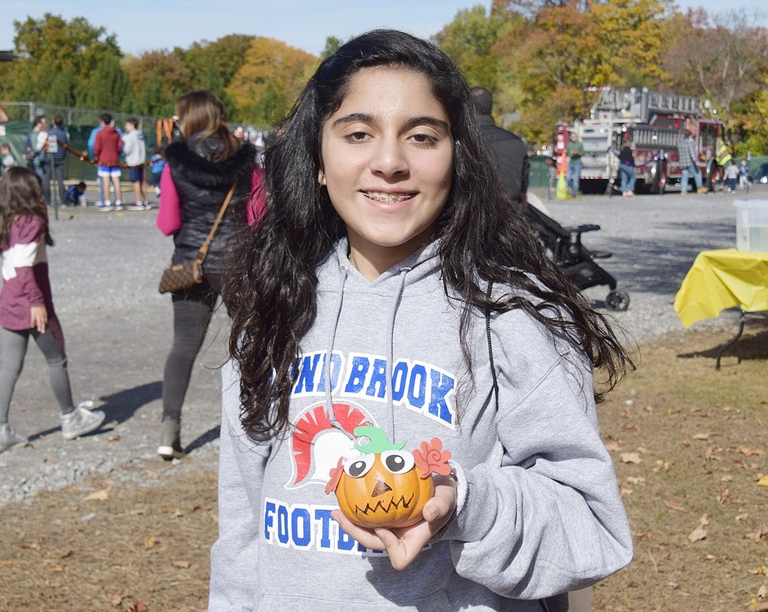 While holding up the pumpkin she decorated, Blind Brook Middle School sixth-grader Mina Jadali poses for a photo.