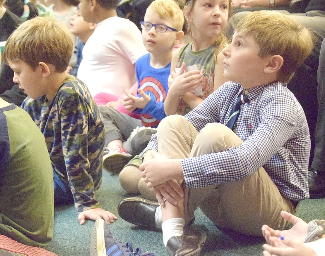 King Street School second-grader Nicholas Allmashy sits among his peers, immersed by the ceremony speakers before going on stage to give a rose to a soldier.