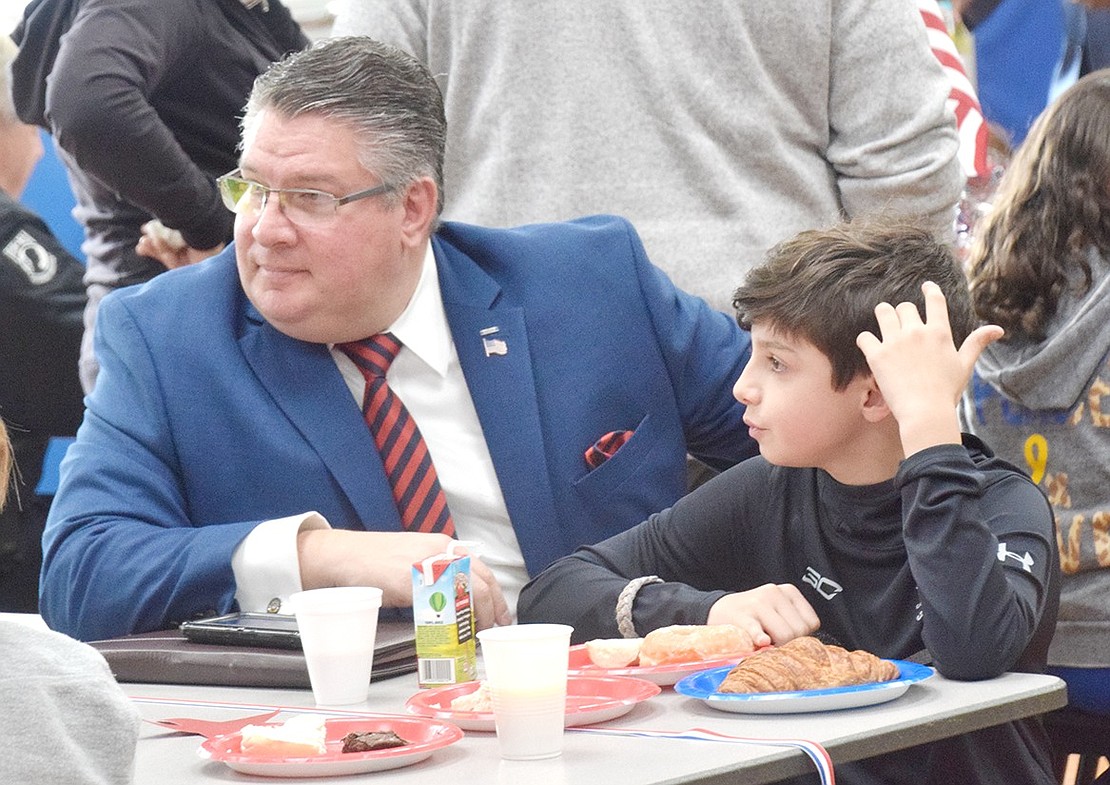 Celebrating his last year as a King Street Veterans Day organizer, William Villanova enjoys the traditional after ceremony breakfast with his fifth-grade son Nicholas.