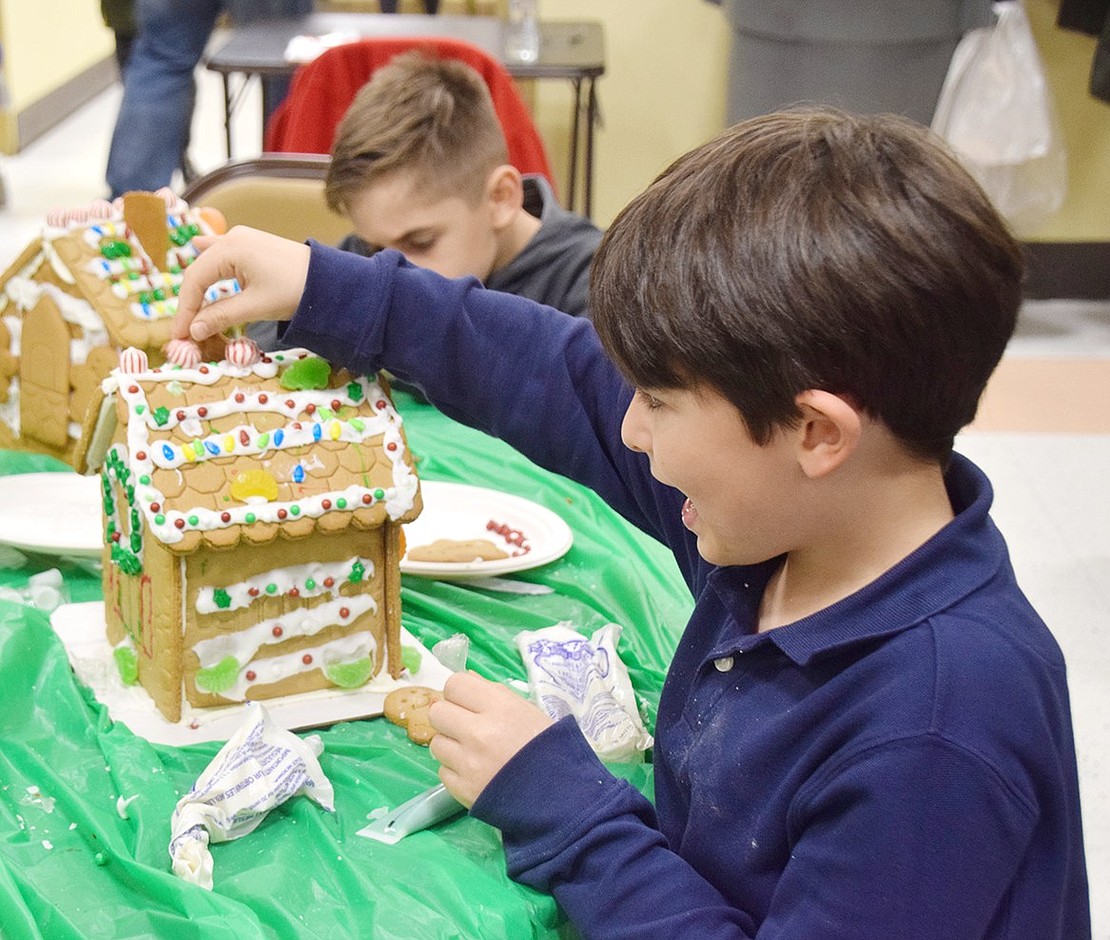 Small candy canes, gummies and colorful candies were some of the finishing touches Ridge Street School third-grader Henry Schofield added to his gingerbread house at the 32 Garibaldi Pl. event.