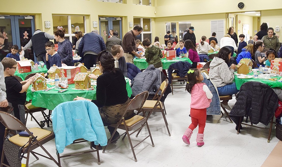 Children and their parents danced to holiday music, ate sweets and laughed as they designed and created gingerbread houses at the Posillipo Center last Friday.