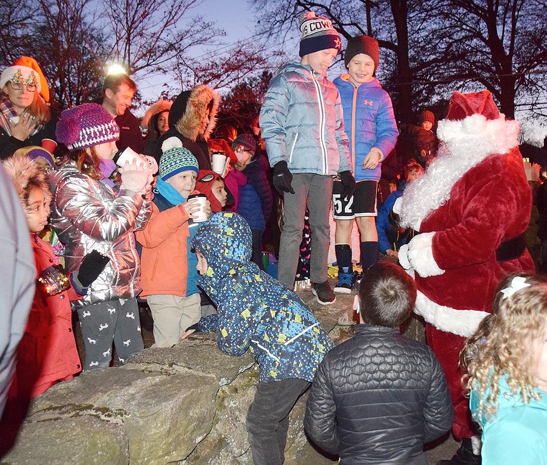 Children eagerly run to the Rye Town Park corner for a chance to meet Santa Claus, played by Armonk resident Jeff Fernandes, and give him high fives.