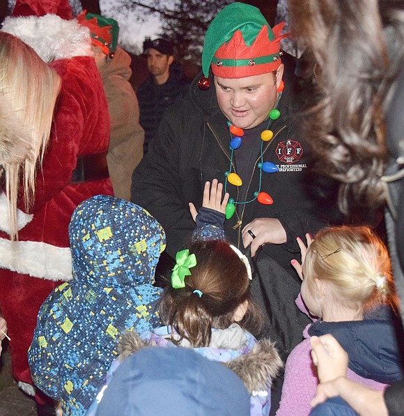 City of Rye firefighter, Port Chester resident and Santa Claus helper Max Billington hands out candy canes to children before the tree lighting.