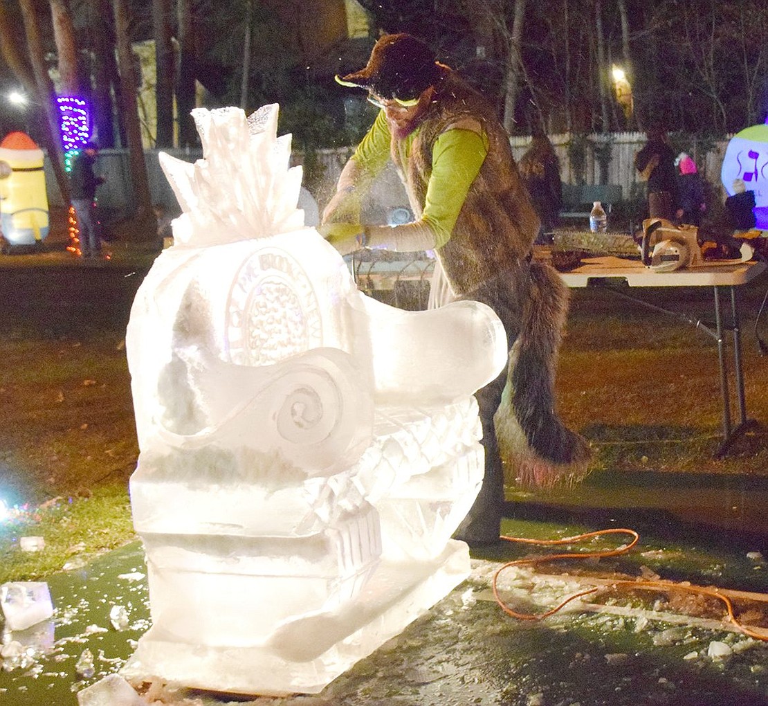 Ice carver Eric Wagner sculpts a bench with his chainsaw that resembles a throne with a Village of Rye Brook seal.