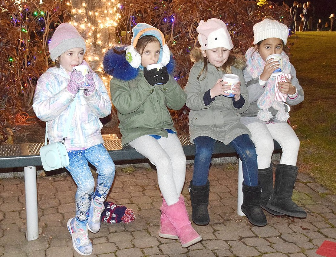 Ridge Street Elementary School first-graders Shannon Murphy (left), Shyla Schroeder, Audrey Peña and Charlotte Sundheim take a break from the activities to sip some hot chocolate.