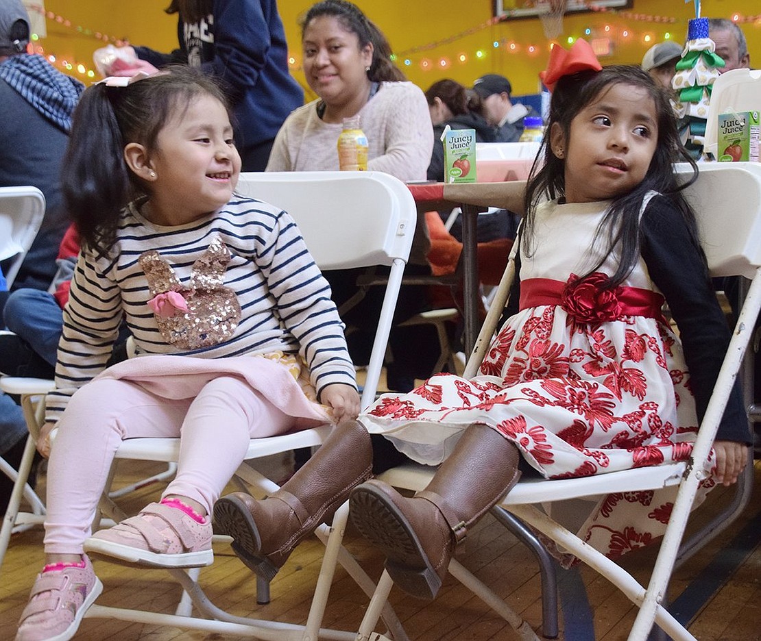 Port Chester residents Kayla Cuadros (left), 3, smiles at 4-year-old Stephanie Rodriguez as they prepare to meet Jolly Old Saint Nicholas.