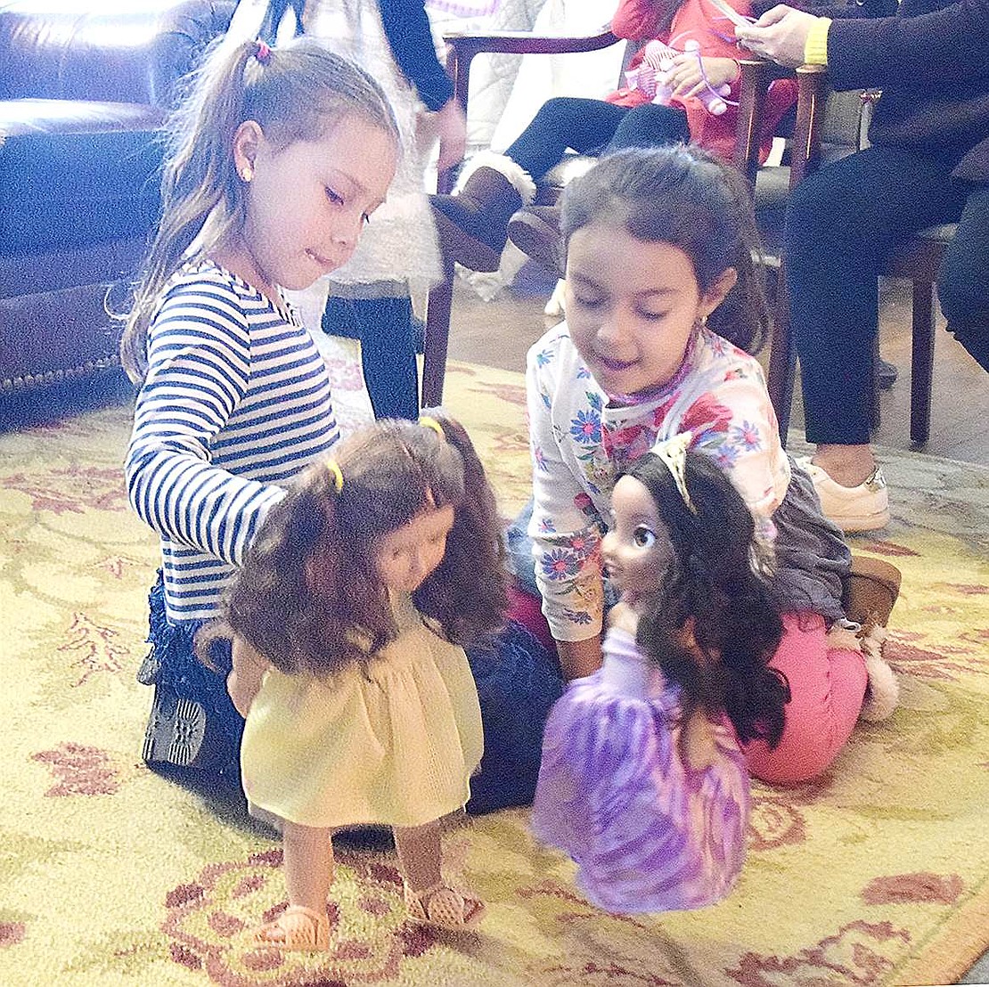 Jocelyn Goyburu (left) and Melinda Cardoso warm up by the fireplace as they play with their toys at the Girl Scout House in Lyon Park on Sunday, Jan. 19. The Park Avenue School first-graders are getting their energy out after brunch at “My Doll and Me Tea,” a Port Chester/Rye Brook Girl Scouts fundraiser to benefit the organization’s scholarship fund.