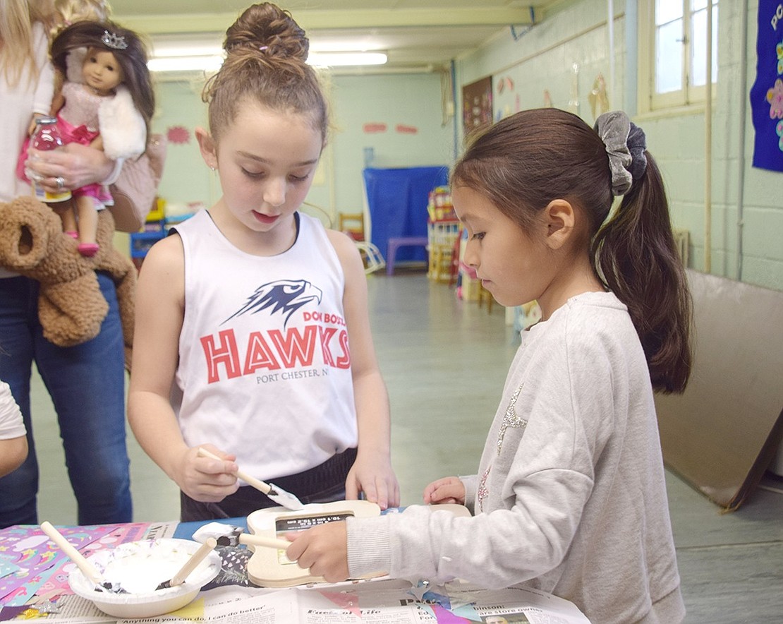 Four hands are better than two. King Street School friends, 8-year-old Madison McConnell (left) and Karly Omeara, 7, spend their arts and crafts time decorating a picture frame together.