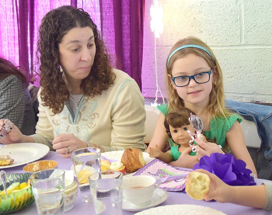 King Street School first-grader Arianna Butkiewicz hugs her American Girl Doll and enjoys brunch with friends as her mother Marissa curiously looks on.