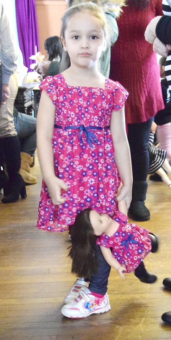 Waiting in line to partake in the raffle, 4-year-old Haines Boulevard resident Sophia Castro spins around with her doll Emma, who attended the party with her owner in a matching dress.