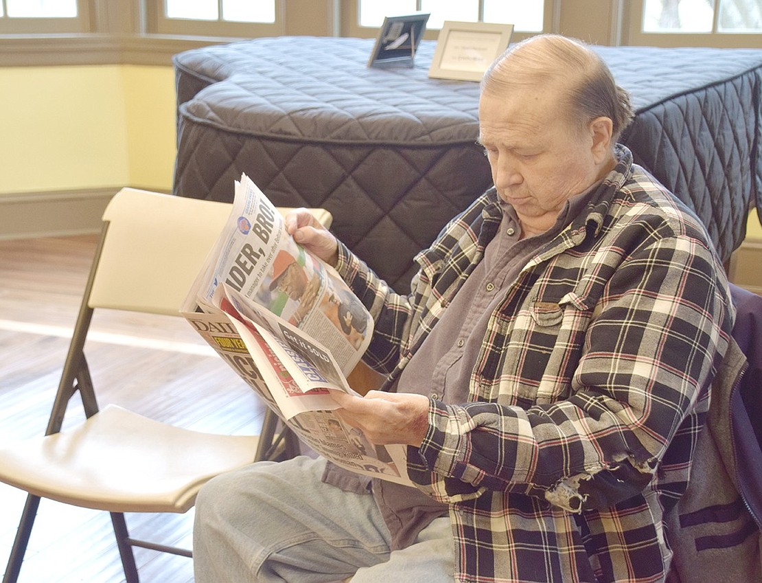 Like in a traditional hair salon, Brush Hollow Crescent resident Richard Cook passes the time before his cut by reading a newspaper.