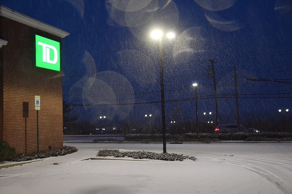 Lightly cascading snow is lit by tall lamps in the parking lot at TD Bank on South Ridge Street as the lights from the Rye Ridge Shopping Center across the way appear in the background like pairs of glowing eyes. Jananne Abel|Westmore News 