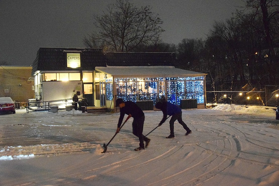 Like skaters on a pond, two staff members from Capers Mediterranean Restaurant clear the parking lot at 541 North Main St. at 5:45 p.m. last Saturday evening, Jan. 18, to make it safe for the dinner crowd as snow fell lightly and accumulated about three inches before ending later that night. Jananne Abel|Westmore News 