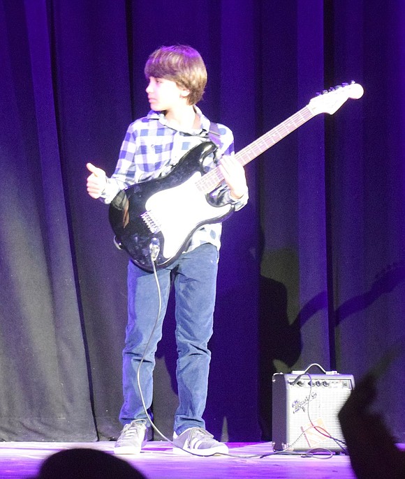 Fourth-grader Rafael Marconi gives a thumbs up after successfully performing a guitar solo from “Smoke on the Water” by Deep Purple. 