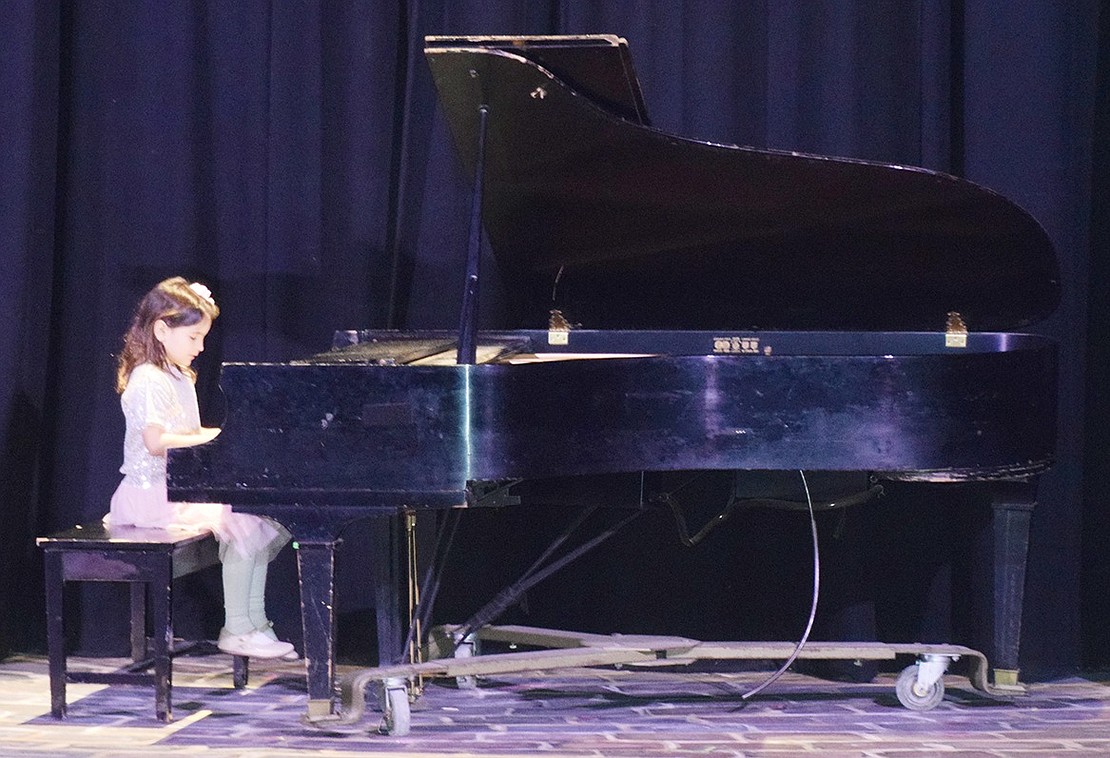 First-grader Clara Marconi masterfully plays “Twinkle, Twinkle Little Star” on the piano.