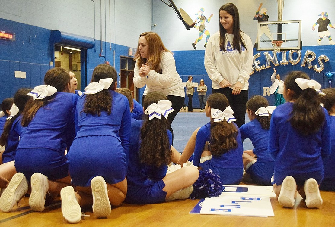 Modified cheer coach Candace Calebrese (left) pumps up the middle school team before they showcase their routine to the public.