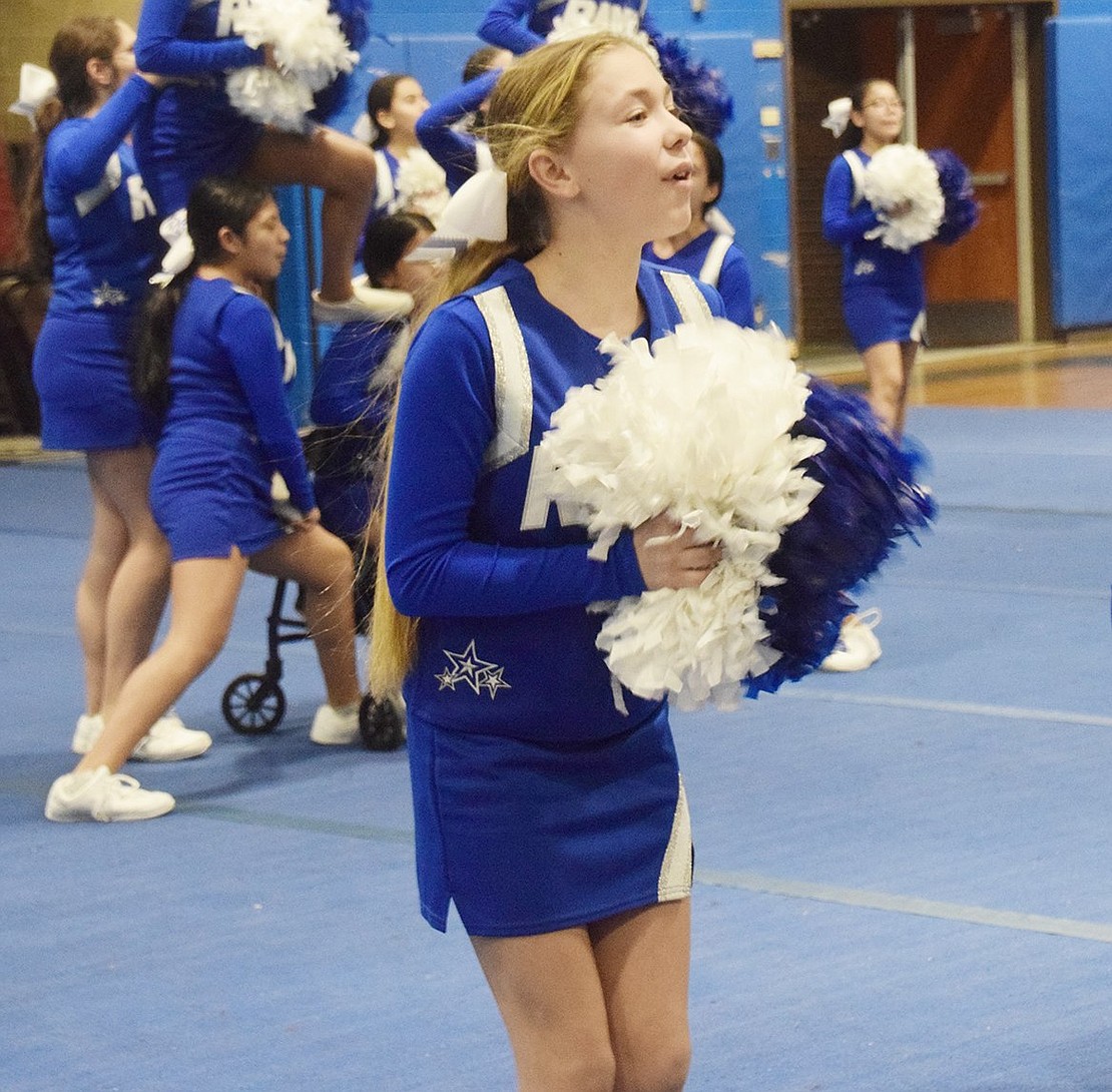 Amongst sky high teammates and fellow cheerers, seventh-grader Natalie Ceruzzi shakes her pom-poms to keep spirits lifted.