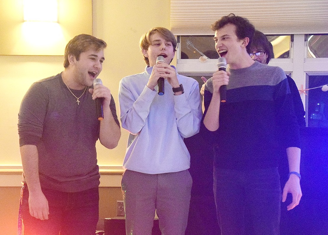 Charismatically taking over the microphones, Port Chester High School Class of ’19 graduate Michael Fallanca (left), sophomore Harrison Callaway and senior Nicolas Arnel blare out the lyrics to “Somebody to Love” by Queen at a dinner and karaoke fundraiser to benefit the High School Drama Club’s upcoming production of “The Little Mermaid” at the Posillipo Community Center on Friday, Feb. 28.