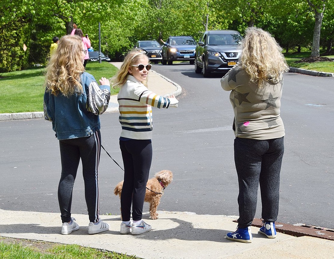 Eighth-grader Wyneth Choset and her sister Lucy, a fifth-grader, watch the parade with their mother Heather as it makes its way up BelleFair Boulevard. 