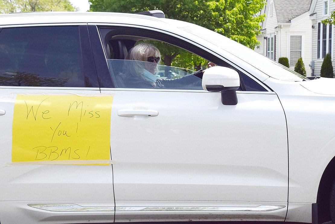 Blind Brook Middle School Principal Patricia Lambert honks her car horn as she passes students and families on BelleFair Boulevard.