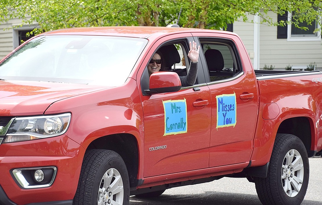 Seventh-grade teacher Elizabeth Connolly happily greets students from her truck.
