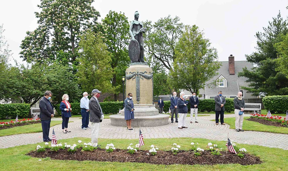 Despite mandated social distancing and gatherings limited to 10 due to COVID-19, a last-minute Memorial Day ceremony was organized at Veterans’ Memorial Park in Port Chester, corner of Westchester Avenue and North Regent Street, on Monday, May 25. Local politicians and school board members gather at the central monument in the park.