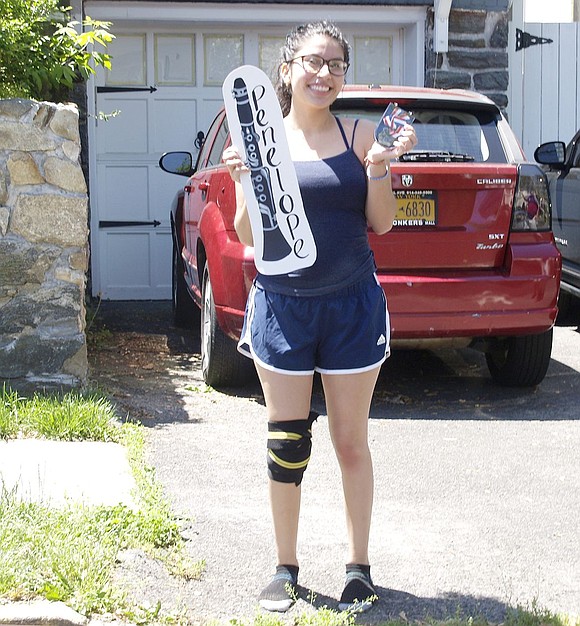 Port Chester High School senior and clarinetist Penelope Alvarez holds up a cutout of her instrument and an award honoring her contribution to the marching band. Port Chester High School Band Parent Association members and the school’s music teachers drove around the community on Saturday, May 30, to honor the seniors after the annual Band Night performance was cancelled due to the ongoing pandemic. 