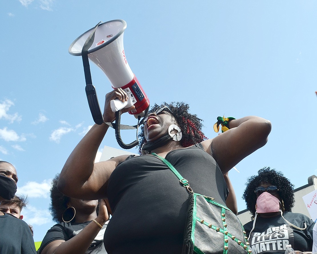 Weber Drive resident Cydney Eunice Carby shouts into the megaphone advocating for peace in the nation.