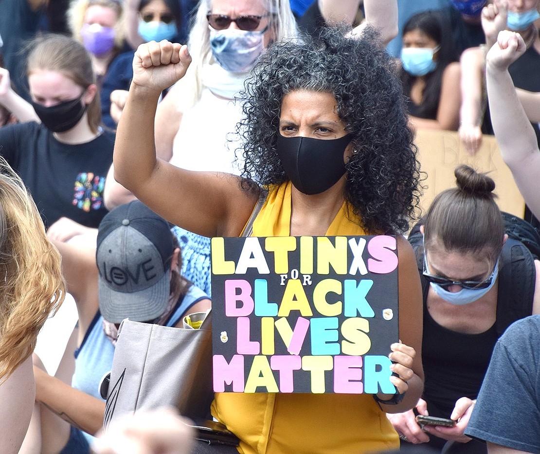 With a solemn face masked by a face covering, Yonkers resident Karen Beltran holds her fist high while showing her Hispanic pride and support for the Black Lives Matter movement.