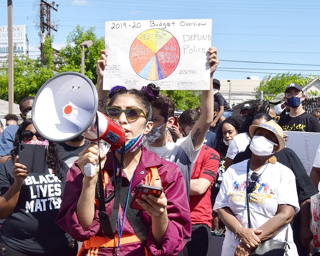 Back dropped by a pie chart reflecting Port Chester’s budget, local activist Zeltzyn Sanchez calls on Village officials to defund the police department.