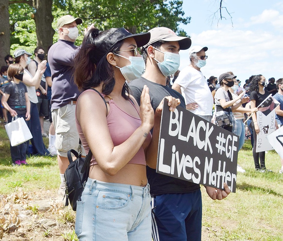 Traveling from New Rochelle to show support for their neighboring community, 22-year-old Sarah Haq and 21-year-old Adam Souda clap while holding a “Black Lives Matter” plaque.