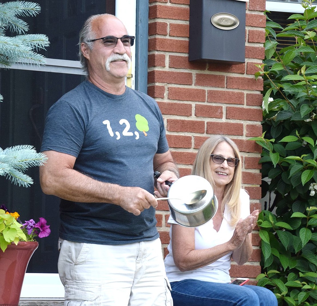 Michael and Linda Pastore happily join 12 of their neighbors on Perry Avenue on Sunday, June 7, in making noise by cheering and banging pots and pans. Each night, street residents join outside at 7 p.m. for the ritual recognizing essential workers. 