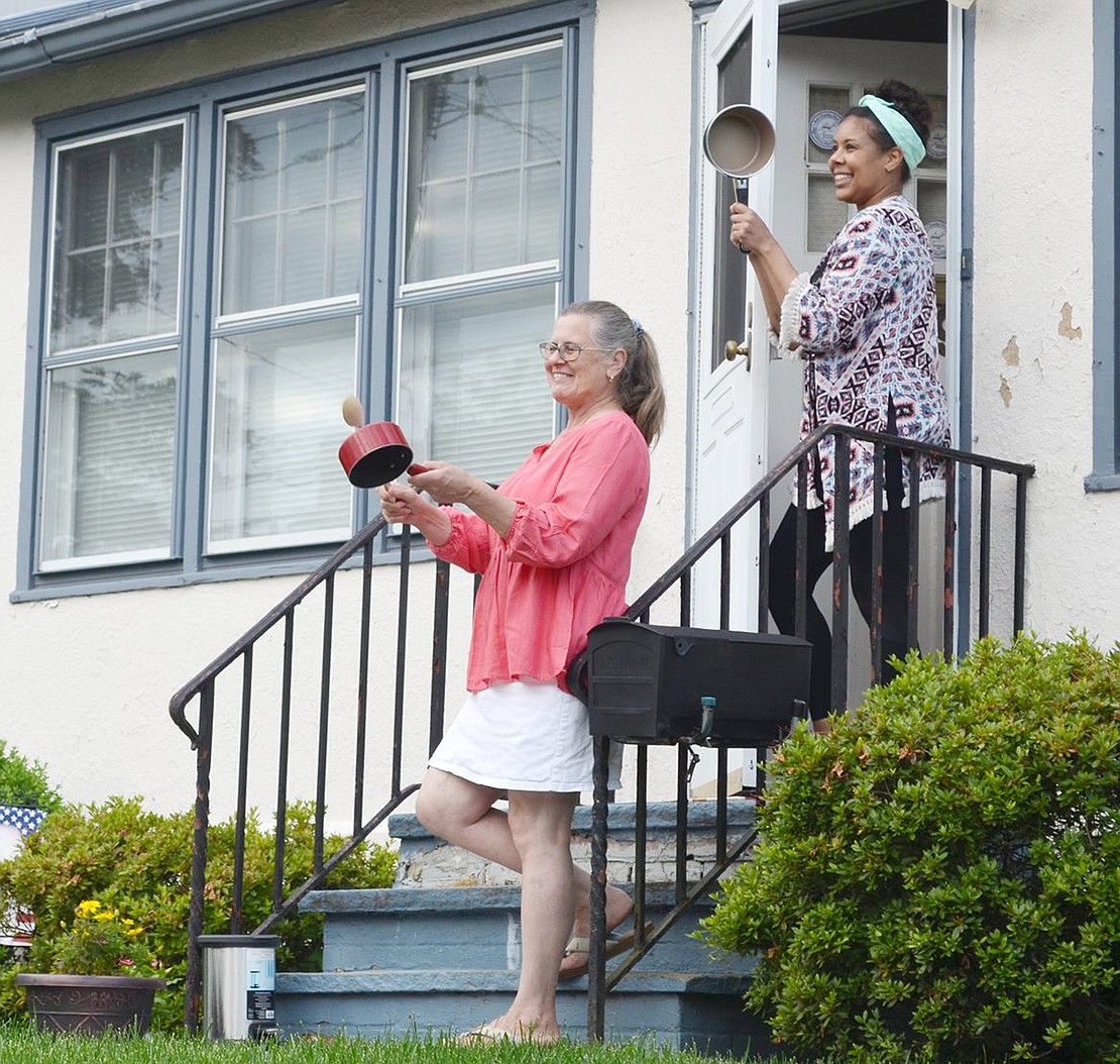 Halina Menifield and her daughter Amber smile as they bang on pots with the rest of their neighbors.