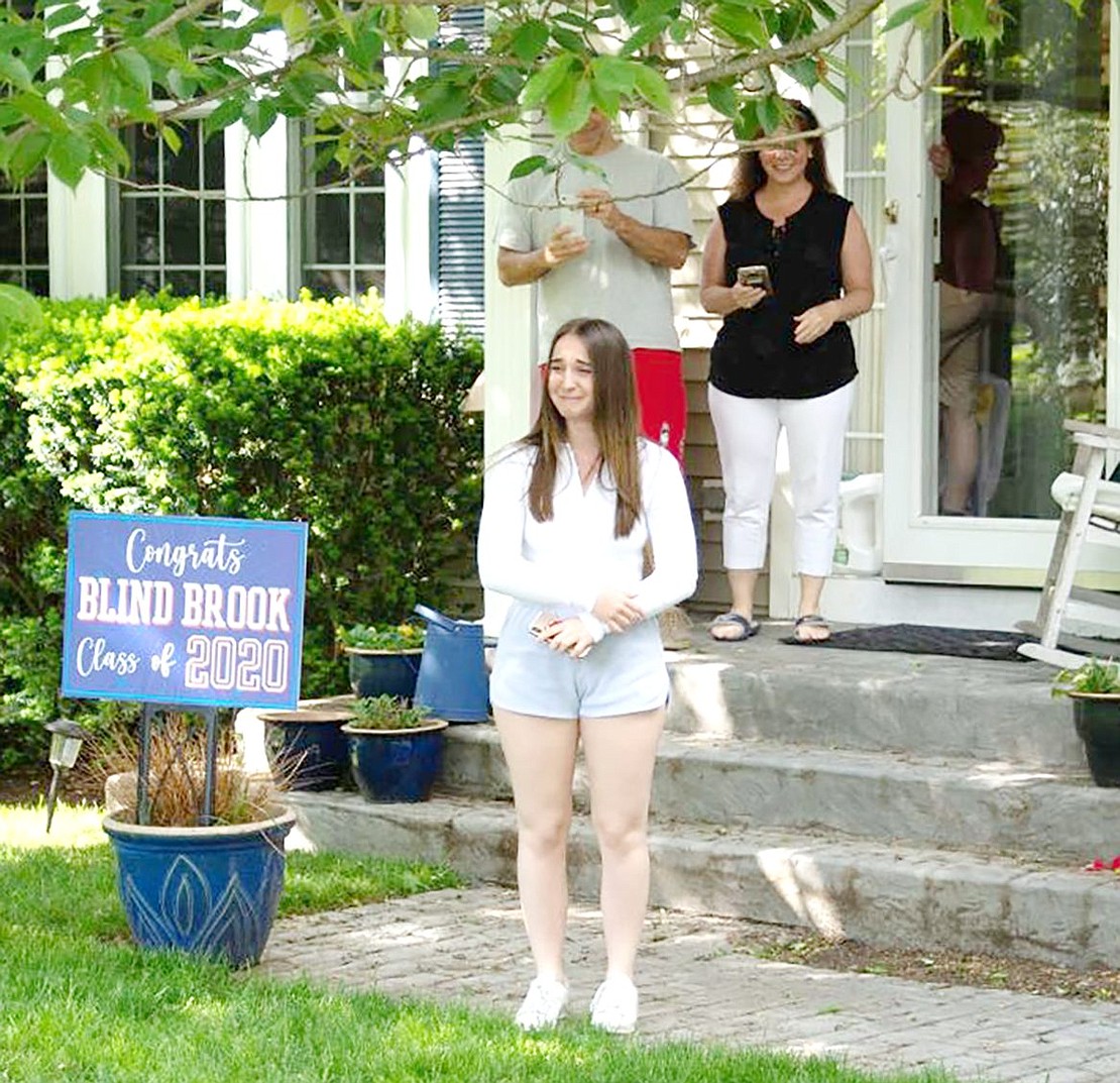 Brought to tears with emotion, Blind Brook High School senior Abby Schlactus stands on her front lawn as she waits to receive flowers celebrating her contributions to the school’s theater program. 