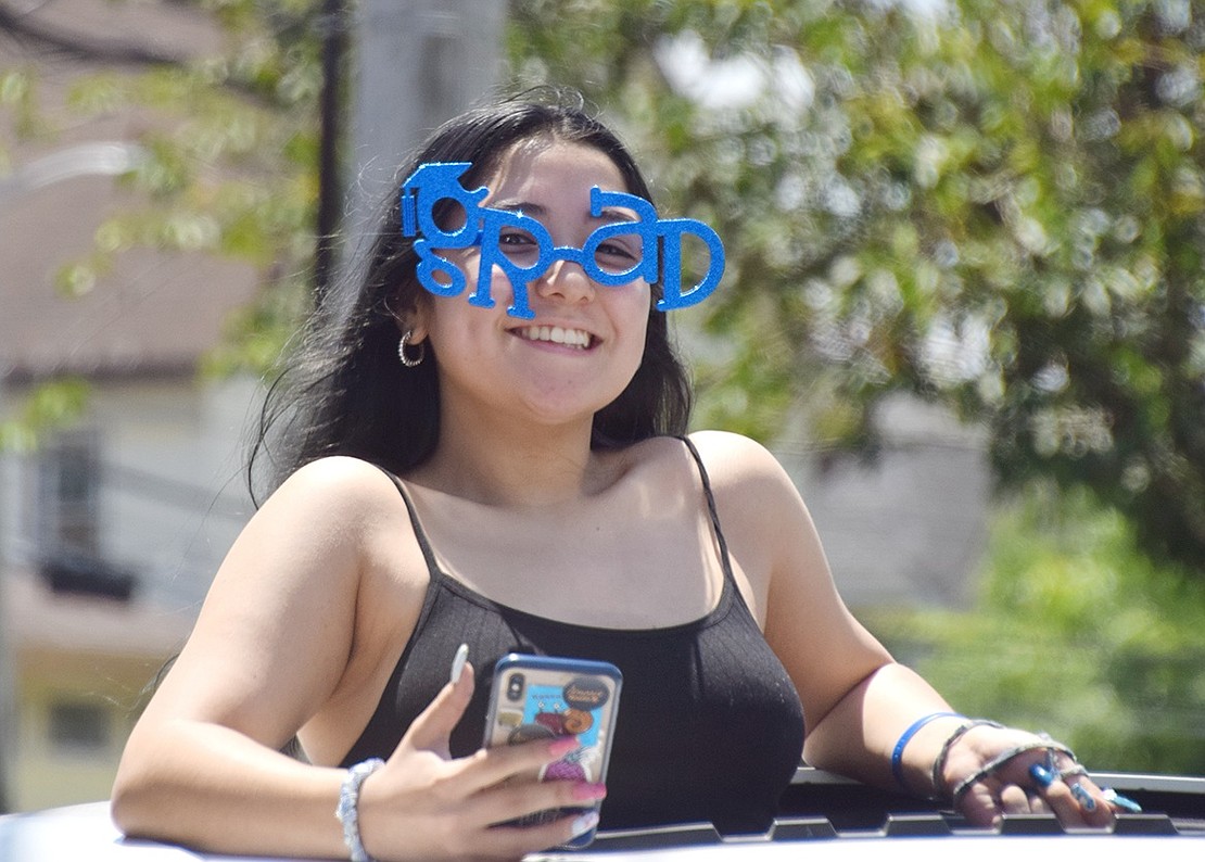 Feeling the pride, Class of 2020 Co-President Emi Oshiro sports a pair of “grad” glasses and relaxes for the ride around town with a top of the car view.