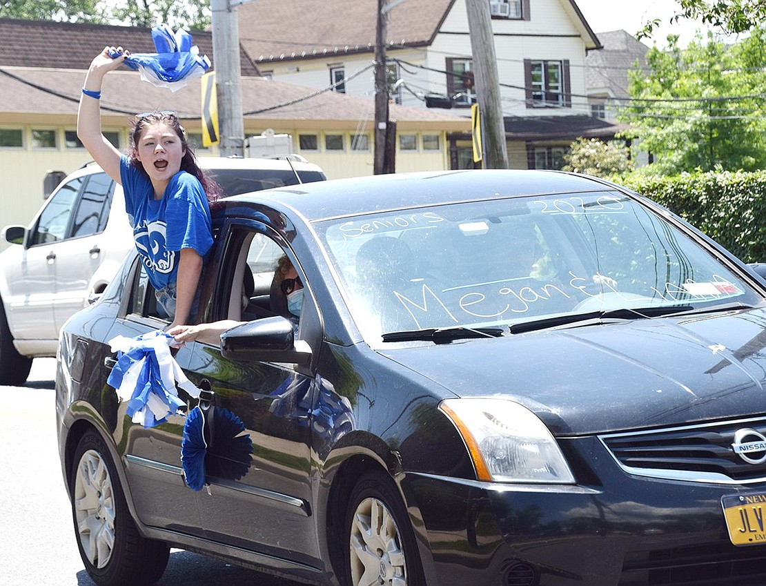 Hanging out the window waving a blue and white pom-pom, Class of 2020 Co-President Megan Gleason screams with pride as she rides down North Regent Street.