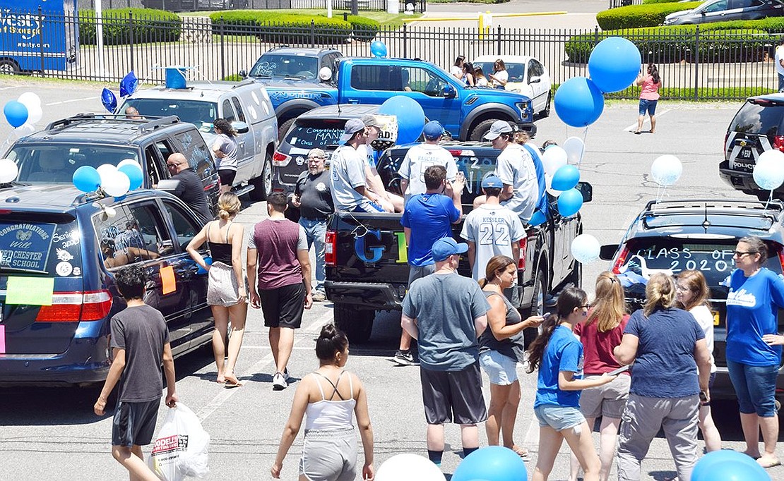Hundreds of Port Chester High School seniors and their families gather in the Kohl’s Shopping Center parking lot with an abundance of blue balloons to collect themselves before the procession.
