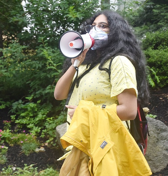 With loudspeaker in hand, rising Blind Brook High School junior Archana Kumaran leads the group in a chant.