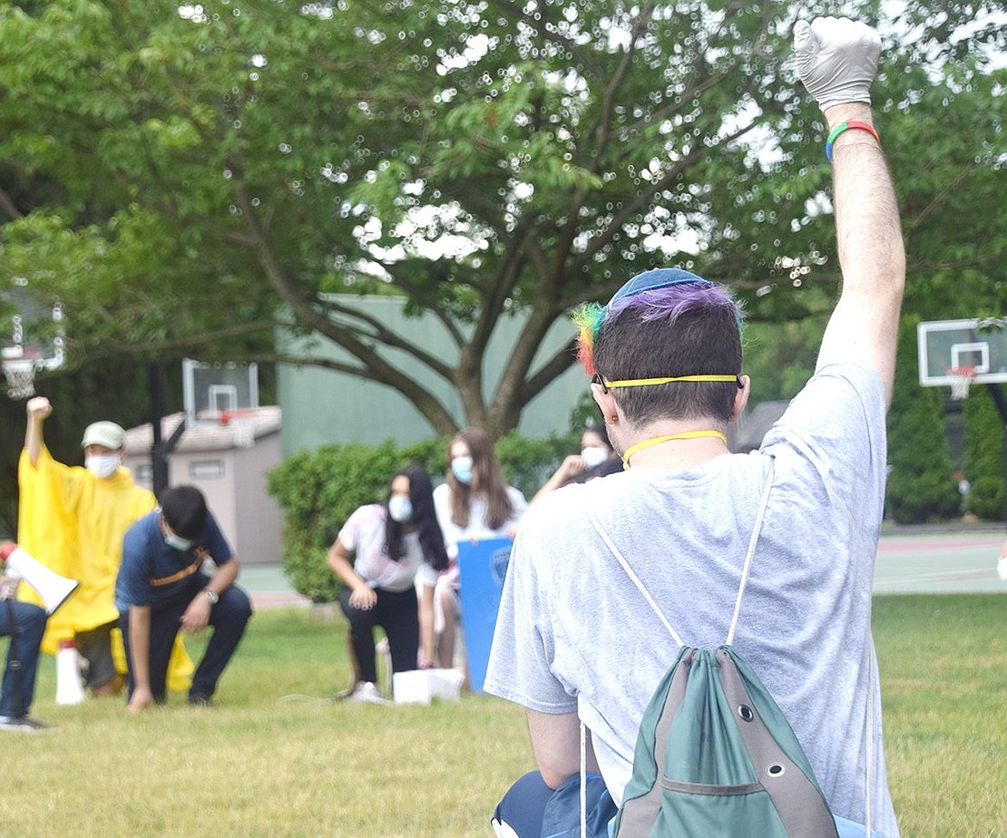 Harry Heftler, a 17-year-old student at John Jay High School in Cross River, takes a knee and holds up his fist as the marchers show their solidarity.