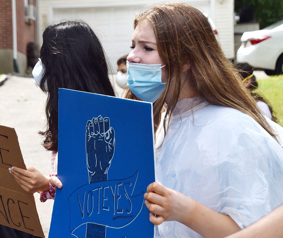 Rising Blind Brook High School junior Clara Hastings marches with the crowd as she holds up a sign to vote yes on bill H.R. 7120, which looks to improve policing practices across the nation.