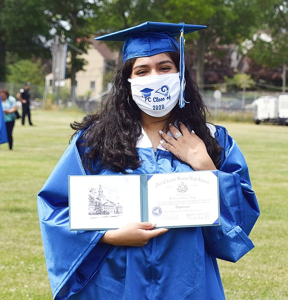 Showing off her diploma before leaving the ceremony, Rebecca Cebanos is touched by pride.