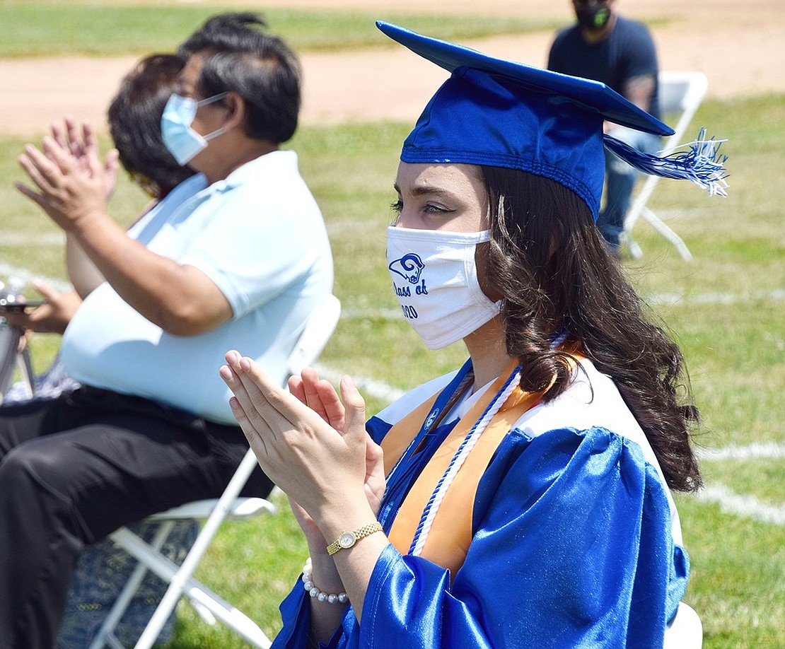 Ikra Konukcu claps for her fellow Class of 2020 graduates as they walk across the dais.